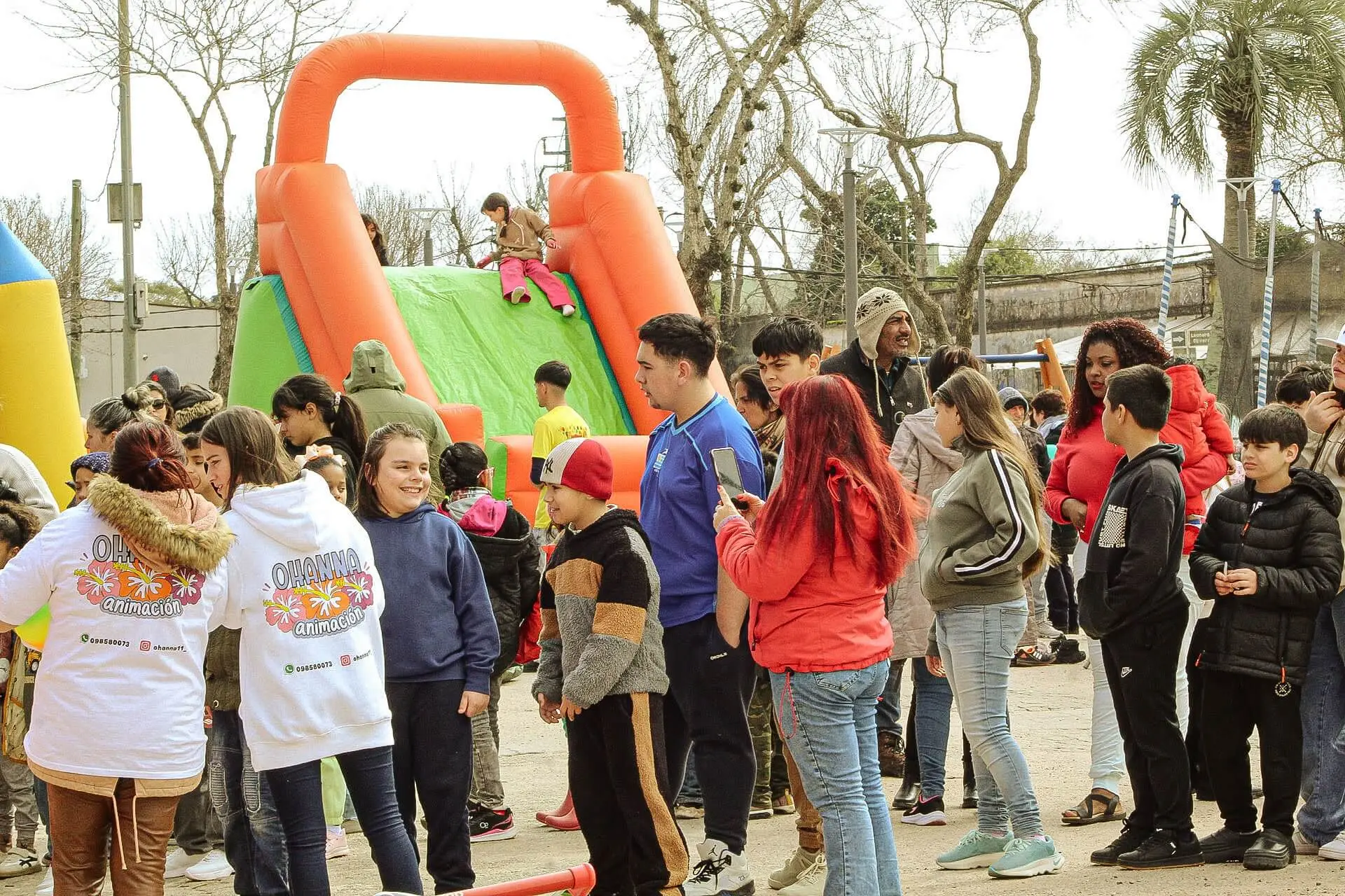Niños y adultos hacen fila frente a un inflable con tobogán, en la plaza del Chuy.