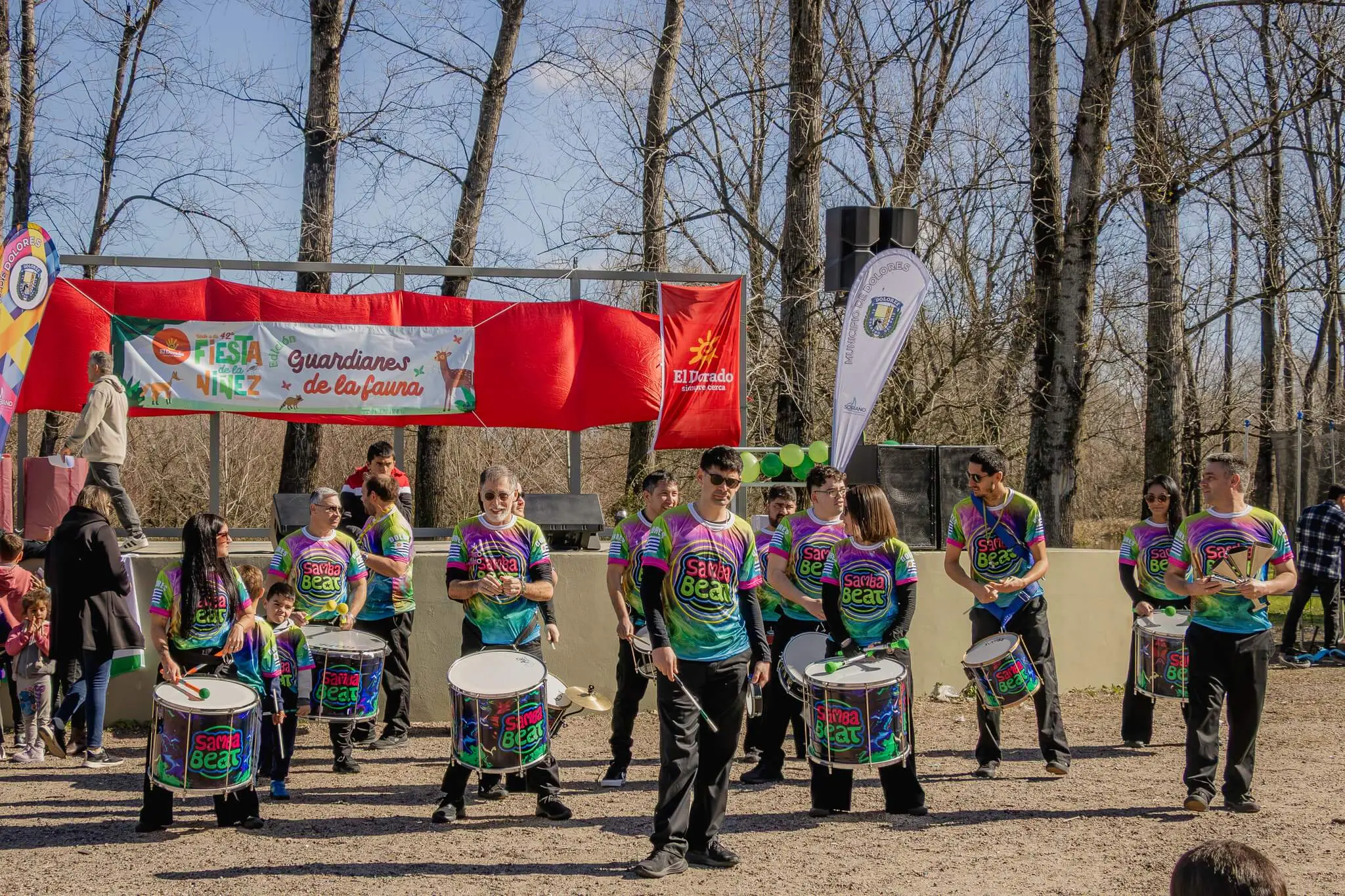 Una batucada con remeras de colores toca tambores frente al escenario de «Guardianes de la fauna».