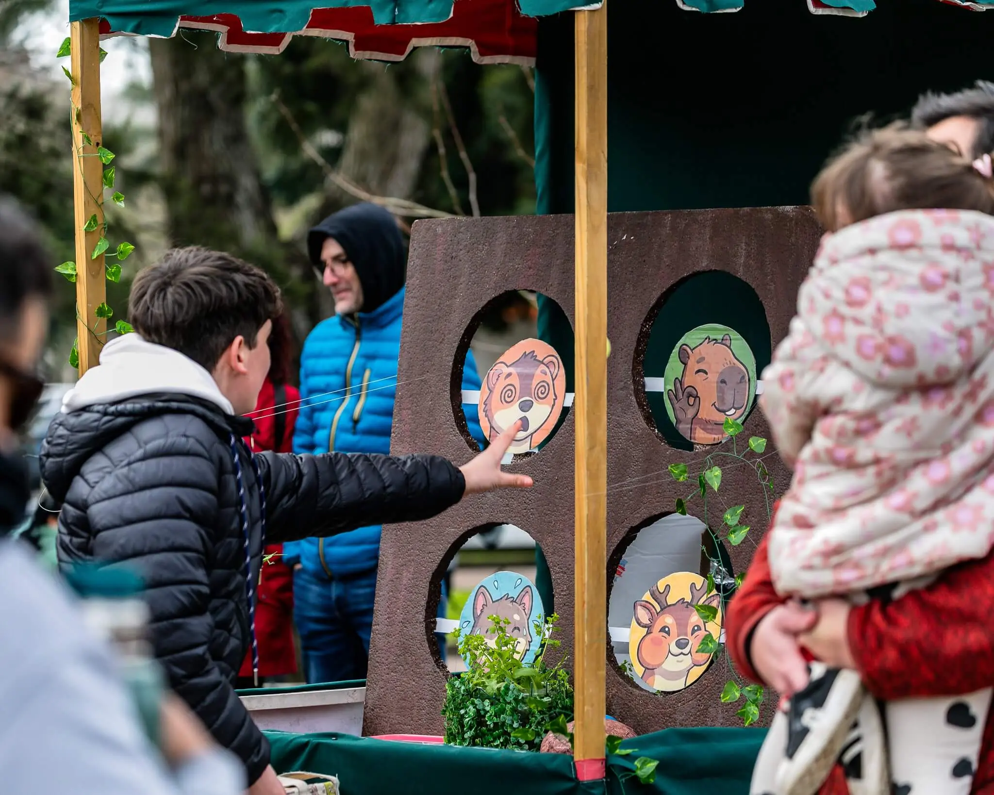 Un niño juega a embocar en un tablero de madera con dibujos de animales autóctonos.