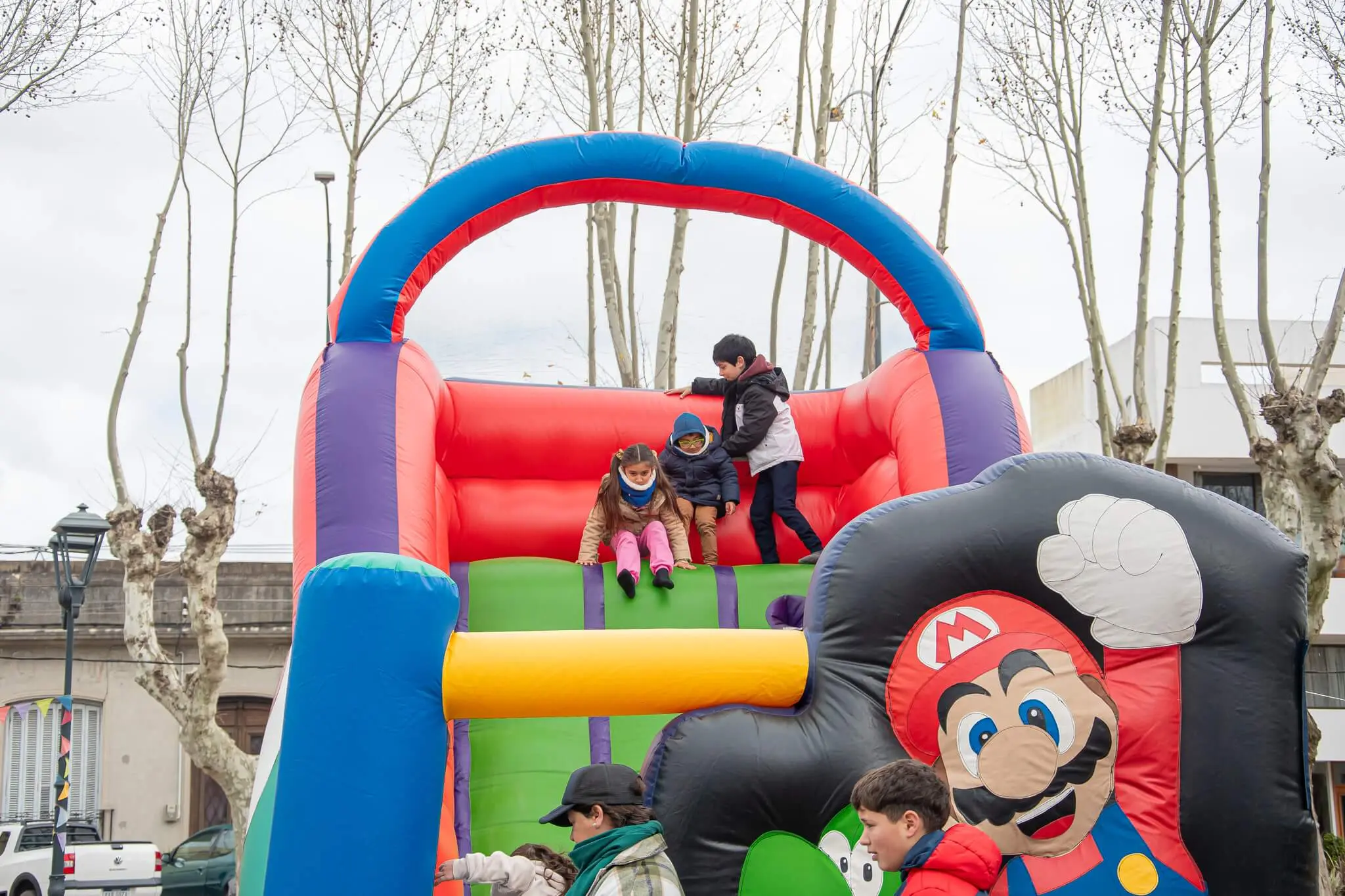 Un niño sale de un inflable decorado con Mario Bros.