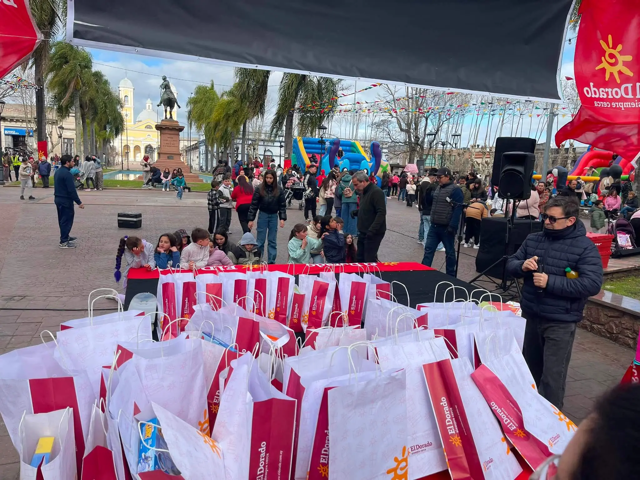 Cientos de bolsas de regalo de El Dorado listas para entregar frente al escenario.