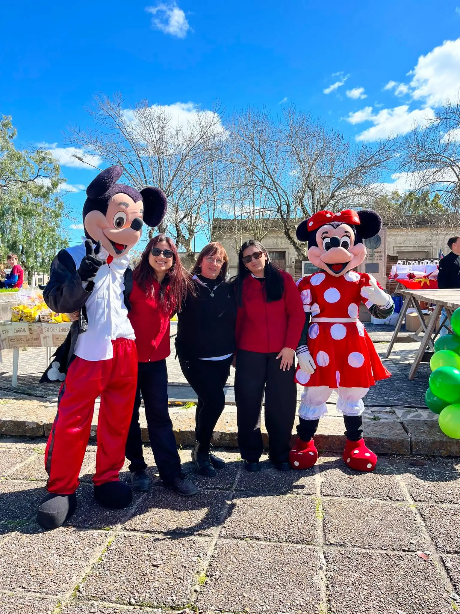 Colaboradoras de El Dorado posan con Mickey y Minnie en la plaza.