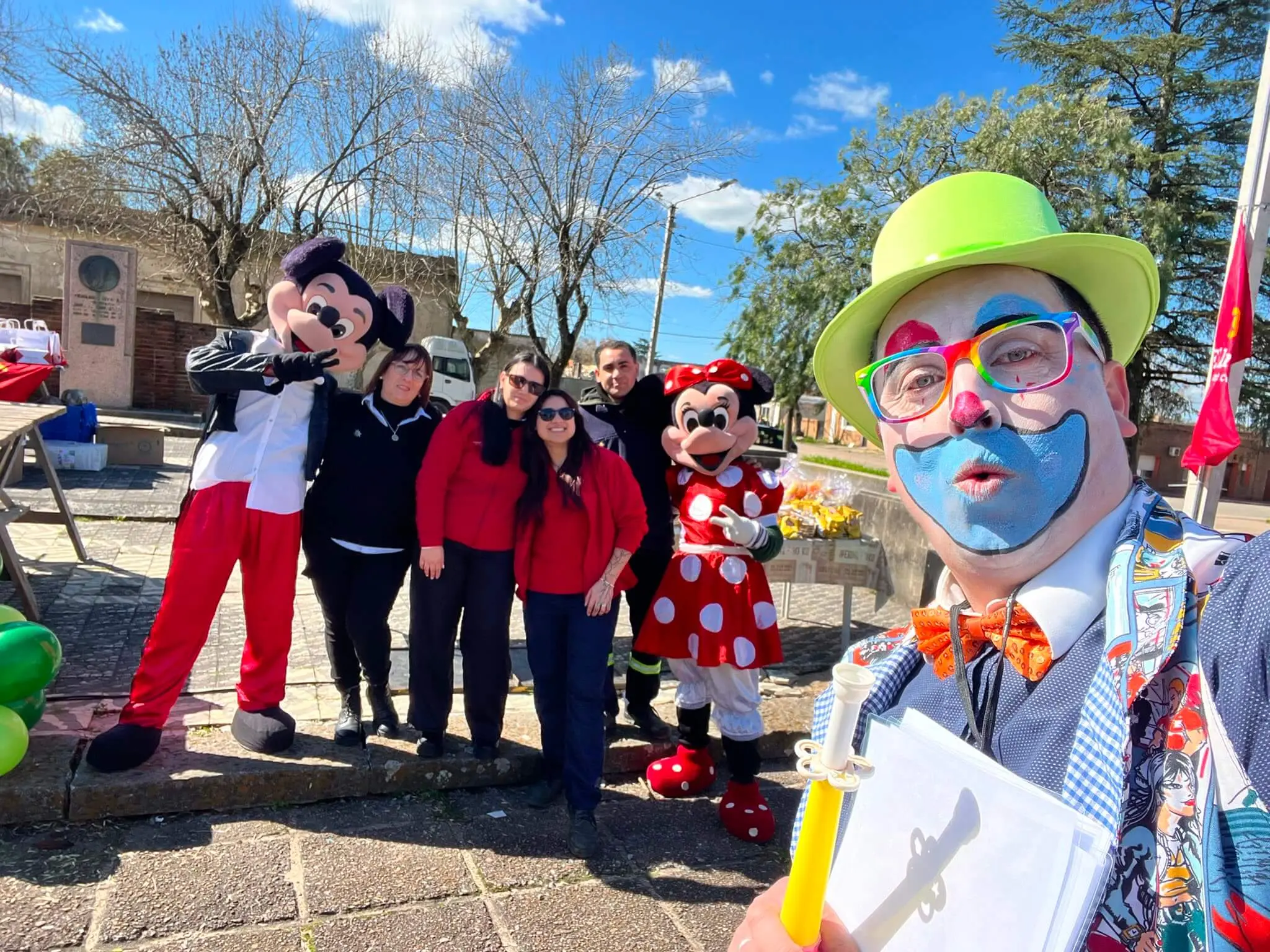 Un payaso con la cara pintada se saca una selfie con el equipo de El Dorado, Mickey y Minnie.